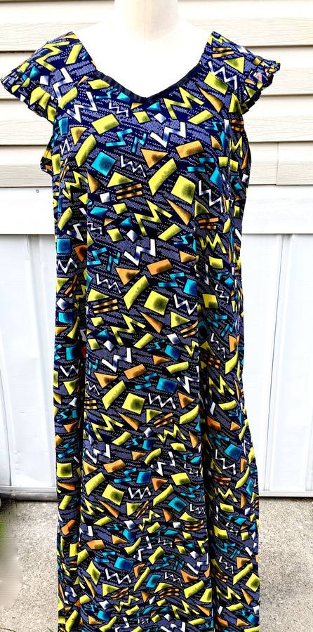 Navy dress with bright yellow, teal, and orange geometric shard pattern