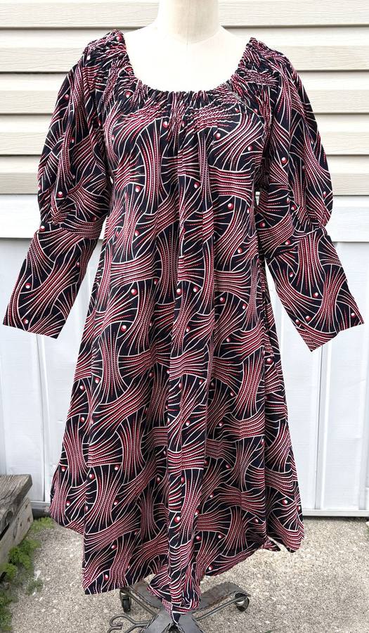 Black, red, and blush wax-print dress with a swirling wave pattern and puff sleeves