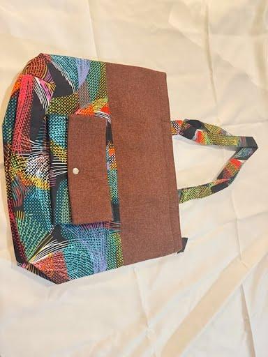 Colorful feather and wave print tote bag with a brown flap pocket