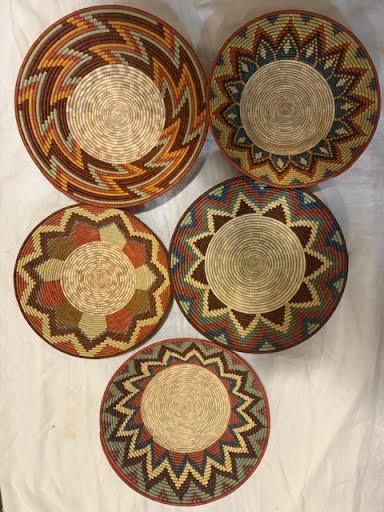 Five round woven trays without handles in assorted star and chevron patterns